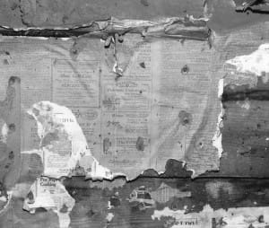 Remnants of old newspaper insulation on a cabin.