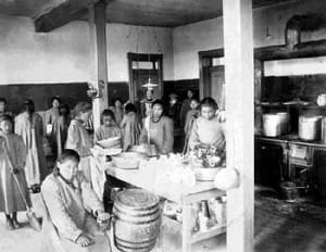 1. Doing chores in kitchen at the Government School - matron standing in the background